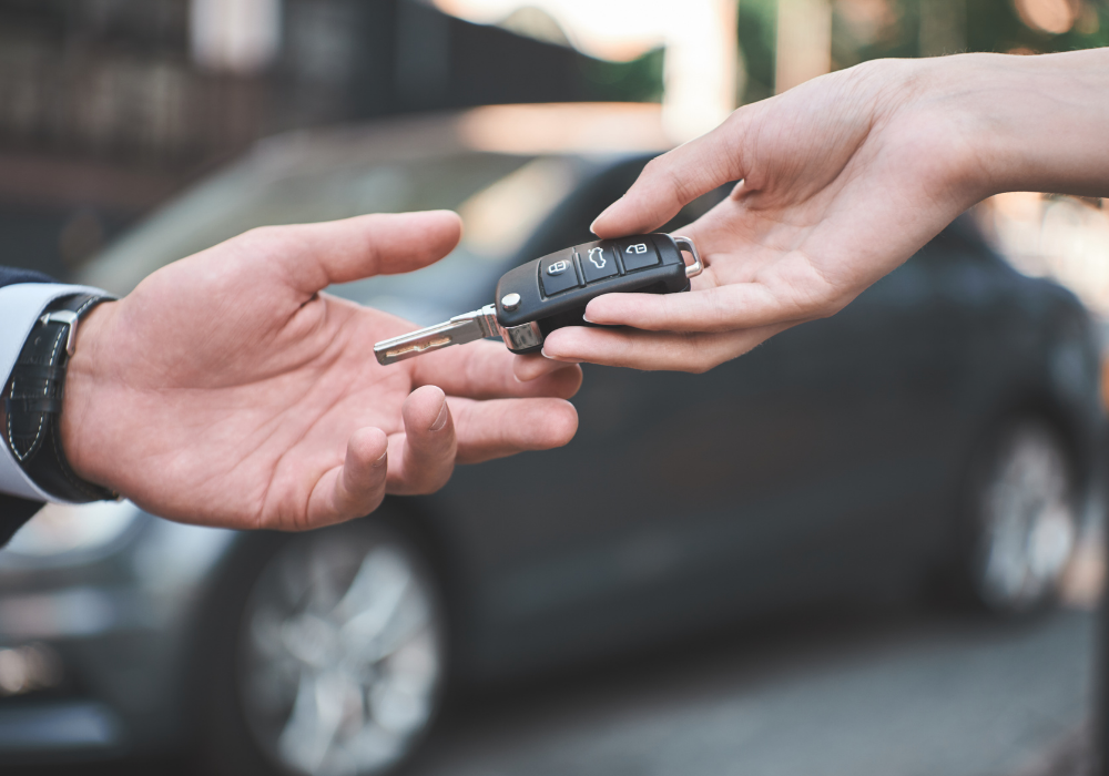 Auto locksmith handing a customer new car keys after replacing the car key for the customer