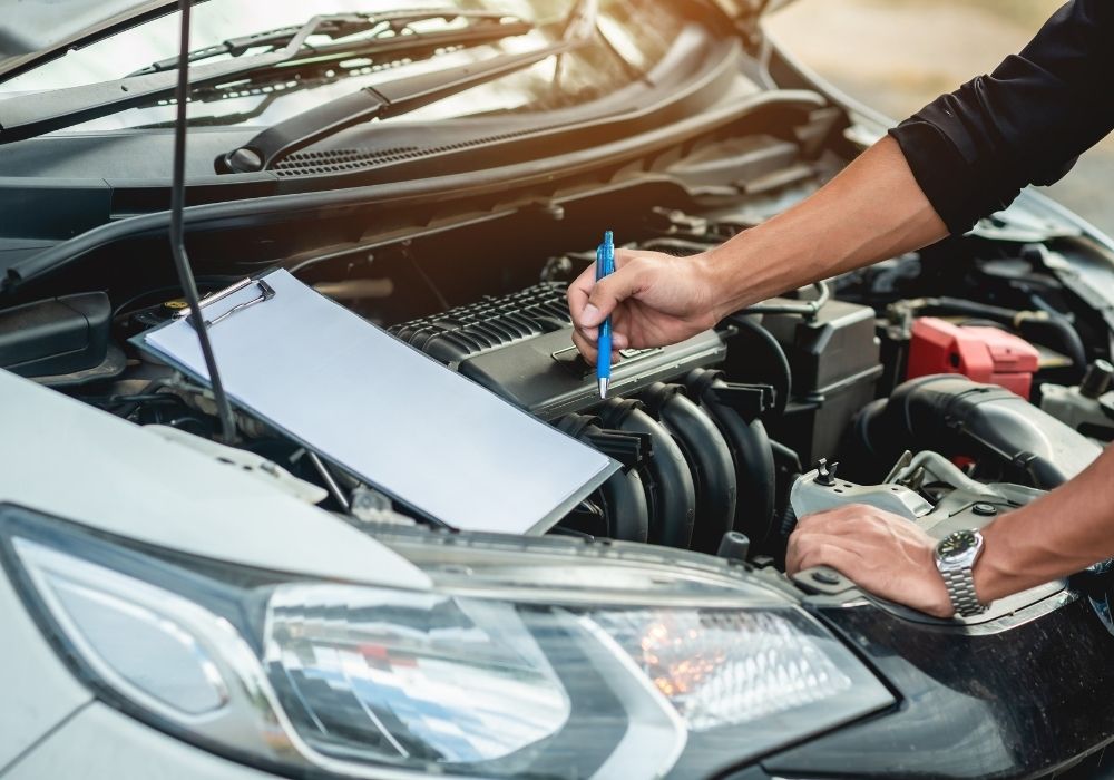 Auto locksmith working on ECU remapping of a car engine to improve the car engine's performance and capabilities